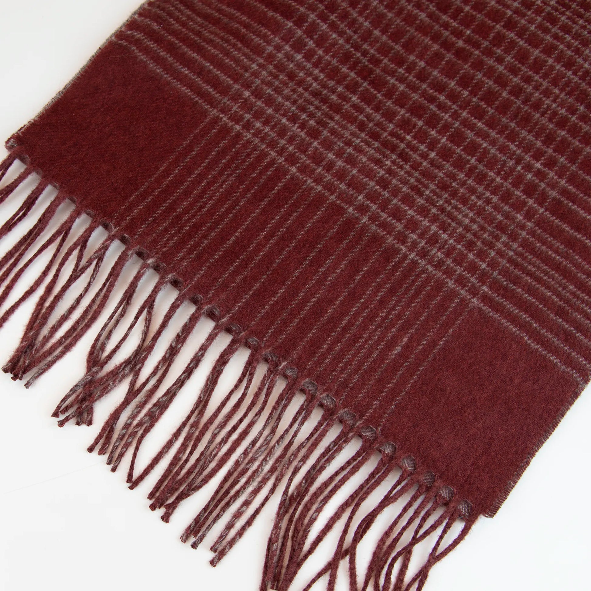 Dettaglio e texture tessuto della Sciarpa in cashmere e seta bordeaux, Made in Italy, pattern lineare e tonalità calde. Design raffinato, facile da abbinare. Morbida, confortevole e leggera, per ogni occasione.
