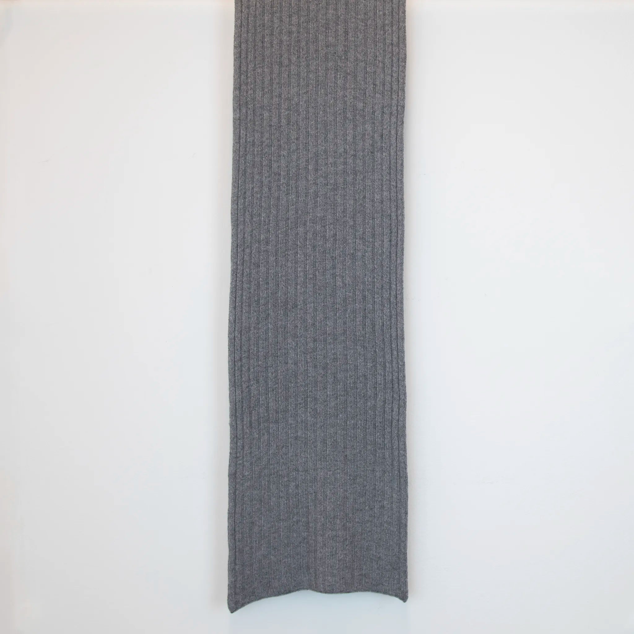 Sciarpa in 100% cashmere grigia, Made in Italy, con trama artigianale realizzata su antichi telai. La struttura robusta e la durata eccezionale del tessuto offrono calore, comfort e leggerezza. Perfetta per aggiungere un tocco di eleganza a qualsiasi outfit, adatta sia a look casual che sofisticati.