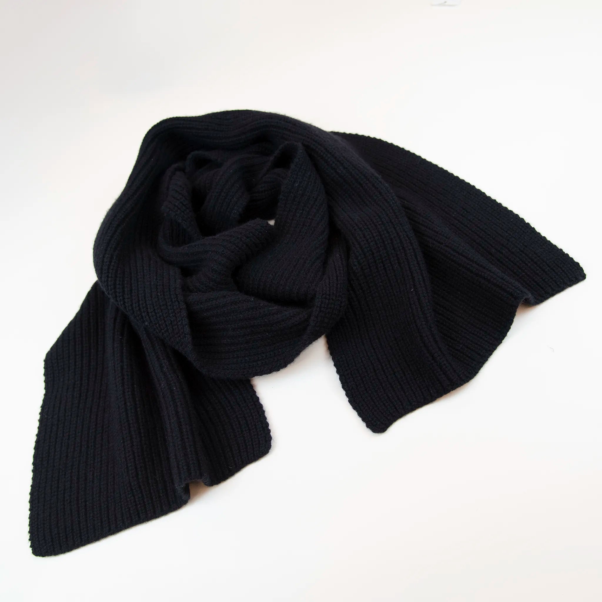 Sciarpa in 100% cashmere nera, Made in Italy, realizzata su telai antichi con trama a nodo perlato. La morbidezza eccezionale e l'effetto compatto e voluminoso della texture conferiscono al filato un calore avvolgente, ideale per le stagioni più fredde. Un accessorio di alta qualità che unisce eleganza e comfort, perfetto per aggiungere un tocco di lusso al tuo look.