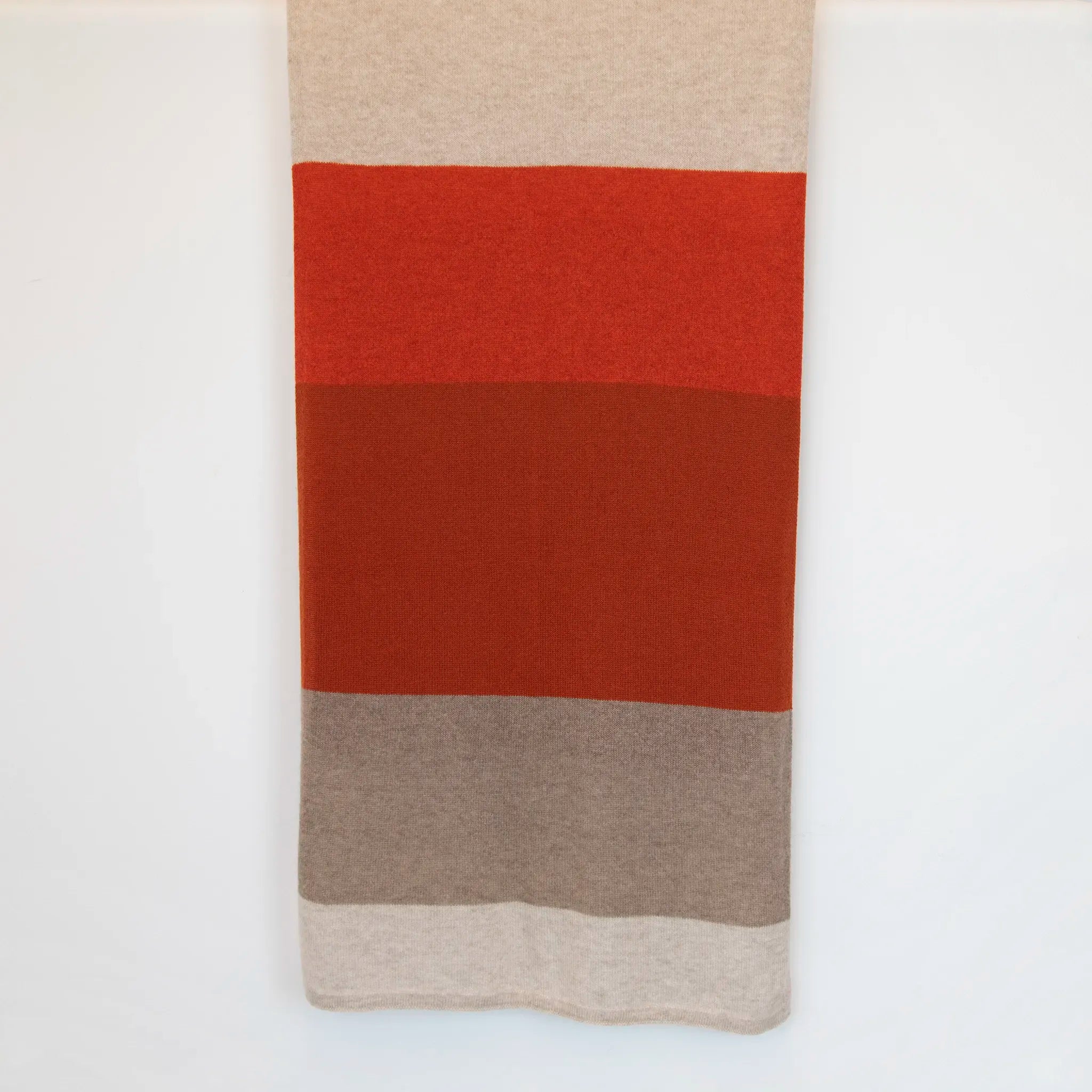 Sciarpa in maglia 100% cashmere arancio e beige, Made in Italy, realizzata su antichi telai. Grazie alla sua ampiezza, può essere utilizzata anche come stola. La pregiata fibra di cashmere offre un'eccezionale finezza e qualità termoisolanti, assicurando calore, protezione e leggerezza in tutte le stagioni. Un accessorio versatile, frutto della creatività di designer specializzati, che aggiunge eleganza e comfort al tuo look.