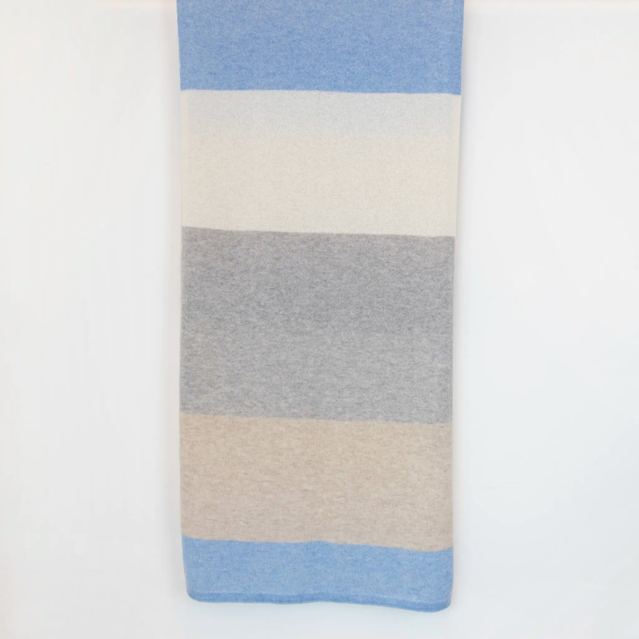 Sciarpa in maglia 100% cashmere celeste, beige e grigia, Made in Italy, realizzata su antichi telai. Grazie alla sua ampiezza, può essere utilizzata anche come stola. La pregiata fibra di cashmere offre un'eccezionale finezza e qualità termoisolanti, assicurando calore, protezione e leggerezza in tutte le stagioni. Un accessorio versatile, frutto della creatività di designer specializzati, che aggiunge eleganza e comfort al tuo look.