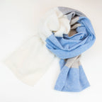 Sciarpa in maglia 100% cashmere celeste, beige e grigia, Made in Italy, realizzata su antichi telai. Grazie alla sua ampiezza, può essere utilizzata anche come stola. La pregiata fibra di cashmere offre un'eccezionale finezza e qualità termoisolanti, assicurando calore, protezione e leggerezza in tutte le stagioni. Un accessorio versatile, frutto della creatività di designer specializzati, che aggiunge eleganza e comfort al tuo look.