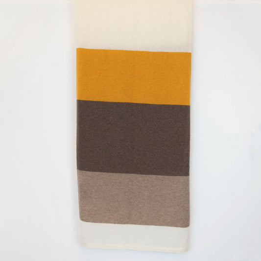Sciarpa in maglia 100% cashmere senape, beige e marrone, Made in Italy, realizzata su antichi telai. Grazie alla sua ampiezza, può essere utilizzata anche come stola. La pregiata fibra di cashmere offre un'eccezionale finezza e qualità termoisolanti, assicurando calore, protezione e leggerezza in tutte le stagioni. Un accessorio versatile, frutto della creatività di designer specializzati, che aggiunge eleganza e comfort al tuo look.