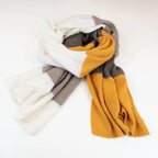 Sciarpa in maglia 100% cashmere senape, beige e marrone, Made in Italy, realizzata su antichi telai. Grazie alla sua ampiezza, può essere utilizzata anche come stola. La pregiata fibra di cashmere offre un'eccezionale finezza e qualità termoisolanti, assicurando calore, protezione e leggerezza in tutte le stagioni. Un accessorio versatile, frutto della creatività di designer specializzati, che aggiunge eleganza e comfort al tuo look.
