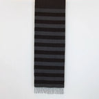 Sciarpa in cashmere e seta, marrone e grigia, Made in Italy, con accostamento di due pattern intramontabili: riga e spinato. Curata nei minimi dettagli, offre straordinaria morbidezza e un comfort avvolgente, rendendola un accessorio elegante e versatile.