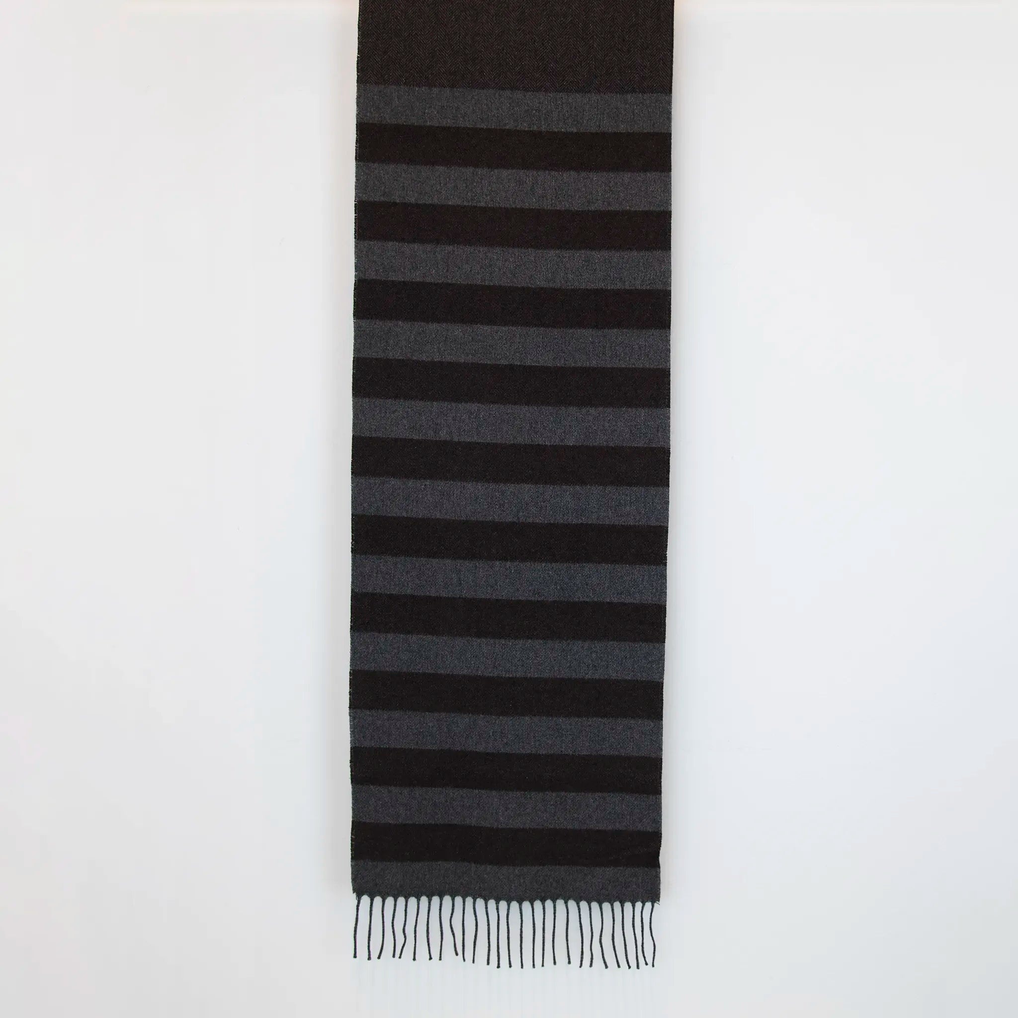 Sciarpa in cashmere e seta, marrone e grigia, Made in Italy, con accostamento di due pattern intramontabili: riga e spinato. Curata nei minimi dettagli, offre straordinaria morbidezza e un comfort avvolgente, rendendola un accessorio elegante e versatile.