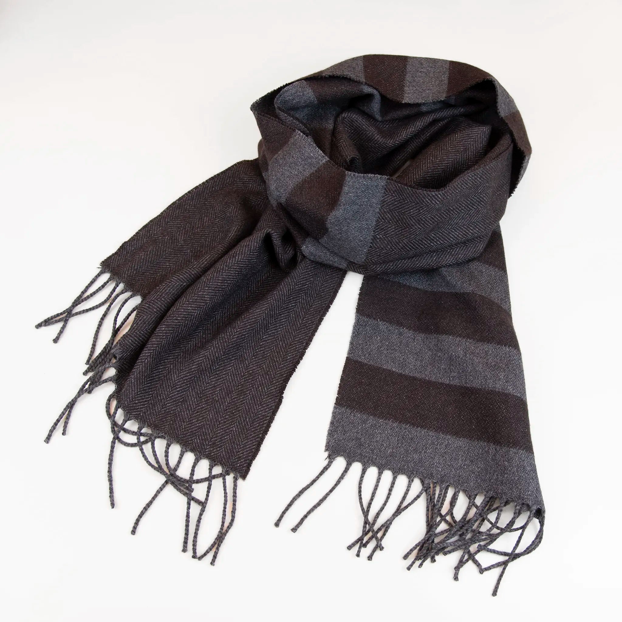 Sciarpa in cashmere e seta, marrone e grigia, Made in Italy, con accostamento di due pattern intramontabili: riga e spinato. Curata nei minimi dettagli, offre straordinaria morbidezza e un comfort avvolgente, rendendola un accessorio elegante e versatile.