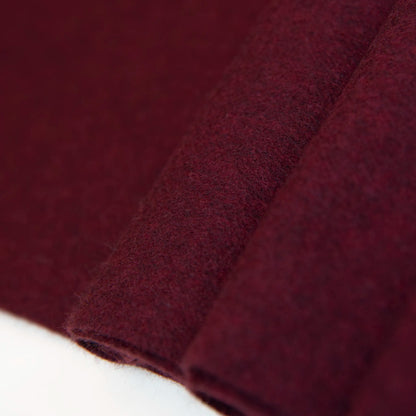 Dettaglio e texture tessuto della Sciarpa in cashmere e seta bordeaux, Made in Italy, con struttura in panno rasato che le conferisce leggerezza e morbidezza avvolgente al tatto. Comoda e versatile, perfetta per essere indossata in ogni occasione.