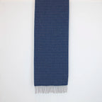 Sciarpa in 100% cashmere blu, Made in Italy, con intramontabile pattern ad intreccio e lavorazione leggera in 3D che accentua la percezione al tatto. Il cashmere di alta qualità offre straordinaria finezza, proprietà termoisolanti e garantisce calore, protezione e leggerezza.