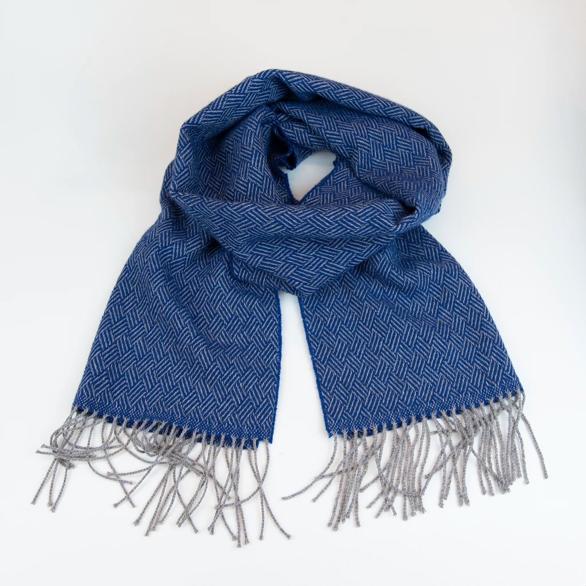 Sciarpa in 100% cashmere blu, Made in Italy, con intramontabile pattern ad intreccio e lavorazione leggera in 3D che accentua la percezione al tatto. Il cashmere di alta qualità offre straordinaria finezza, proprietà termoisolanti e garantisce calore, protezione e leggerezza.