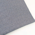 Dettaglio e texture tessuto della Sciarpa in 100% cashmere celeste polvere, Made in Italy, con intramontabile pattern ad intreccio e lavorazione leggera in 3D che accentua la percezione al tatto. Il cashmere di alta qualità offre straordinaria finezza, proprietà termoisolanti e garantisce calore, protezione e leggerezza.