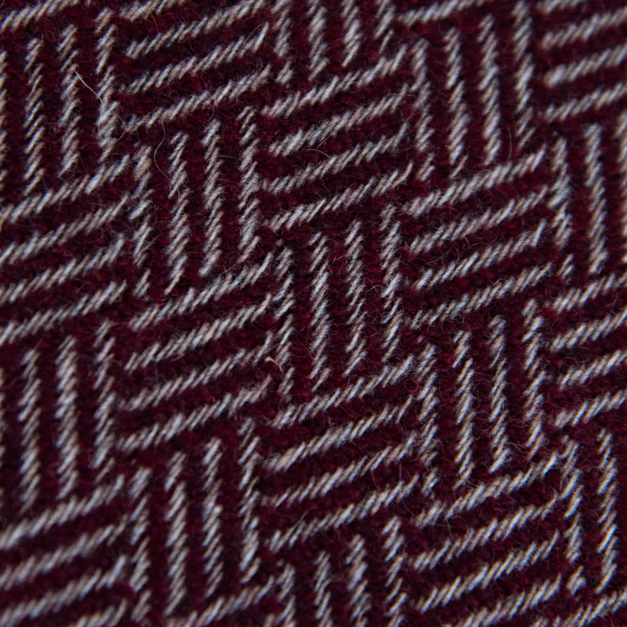 Dettaglio e texture tessuto della Sciarpa in 100% cashmere bordeaux, Made in Italy, con intramontabile pattern ad intreccio e lavorazione leggera in 3D che accentua la percezione al tatto. Il cashmere di alta qualità offre straordinaria finezza, proprietà termoisolanti e garantisce calore, protezione e leggerezza.