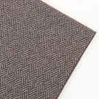 Dettaglio e texture tessuto della Sciarpa in 100% cashmere marrone, Made in Italy, con intramontabile pattern ad intreccio e lavorazione leggera in 3D che accentua la percezione al tatto. Il cashmere di alta qualità offre straordinaria finezza, proprietà termoisolanti e garantisce calore, protezione e leggerezza.