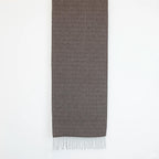 Sciarpa in 100% cashmere marrone, Made in Italy, con intramontabile pattern ad intreccio e lavorazione leggera in 3D che accentua la percezione al tatto. Il cashmere di alta qualità offre straordinaria finezza, proprietà termoisolanti e garantisce calore, protezione e leggerezza.
