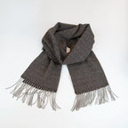 Sciarpa in 100% cashmere marrone, Made in Italy, con intramontabile pattern ad intreccio e lavorazione leggera in 3D che accentua la percezione al tatto. Il cashmere di alta qualità offre straordinaria finezza, proprietà termoisolanti e garantisce calore, protezione e leggerezza.