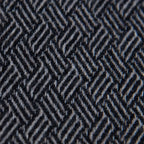 Dettaglio e texture tessuto della Sciarpa in 100% cashmere nera, Made in Italy, con intramontabile pattern ad intreccio e lavorazione leggera in 3D che accentua la percezione al tatto. Il cashmere di alta qualità offre straordinaria finezza, proprietà termoisolanti e garantisce calore, protezione e leggerezza.