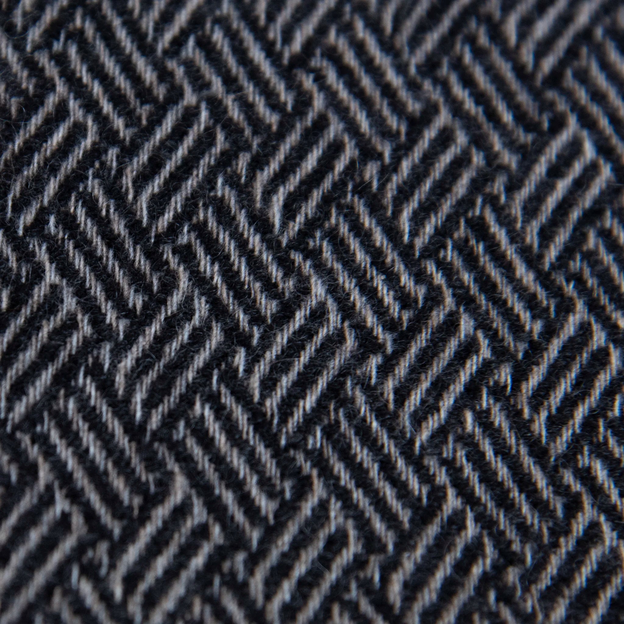 Dettaglio e texture tessuto della Sciarpa in 100% cashmere nera, Made in Italy, con intramontabile pattern ad intreccio e lavorazione leggera in 3D che accentua la percezione al tatto. Il cashmere di alta qualità offre straordinaria finezza, proprietà termoisolanti e garantisce calore, protezione e leggerezza.