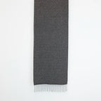 Sciarpa in 100% cashmere nera, Made in Italy, con intramontabile pattern ad intreccio e lavorazione leggera in 3D che accentua la percezione al tatto. Il cashmere di alta qualità offre straordinaria finezza, proprietà termoisolanti e garantisce calore, protezione e leggerezza.