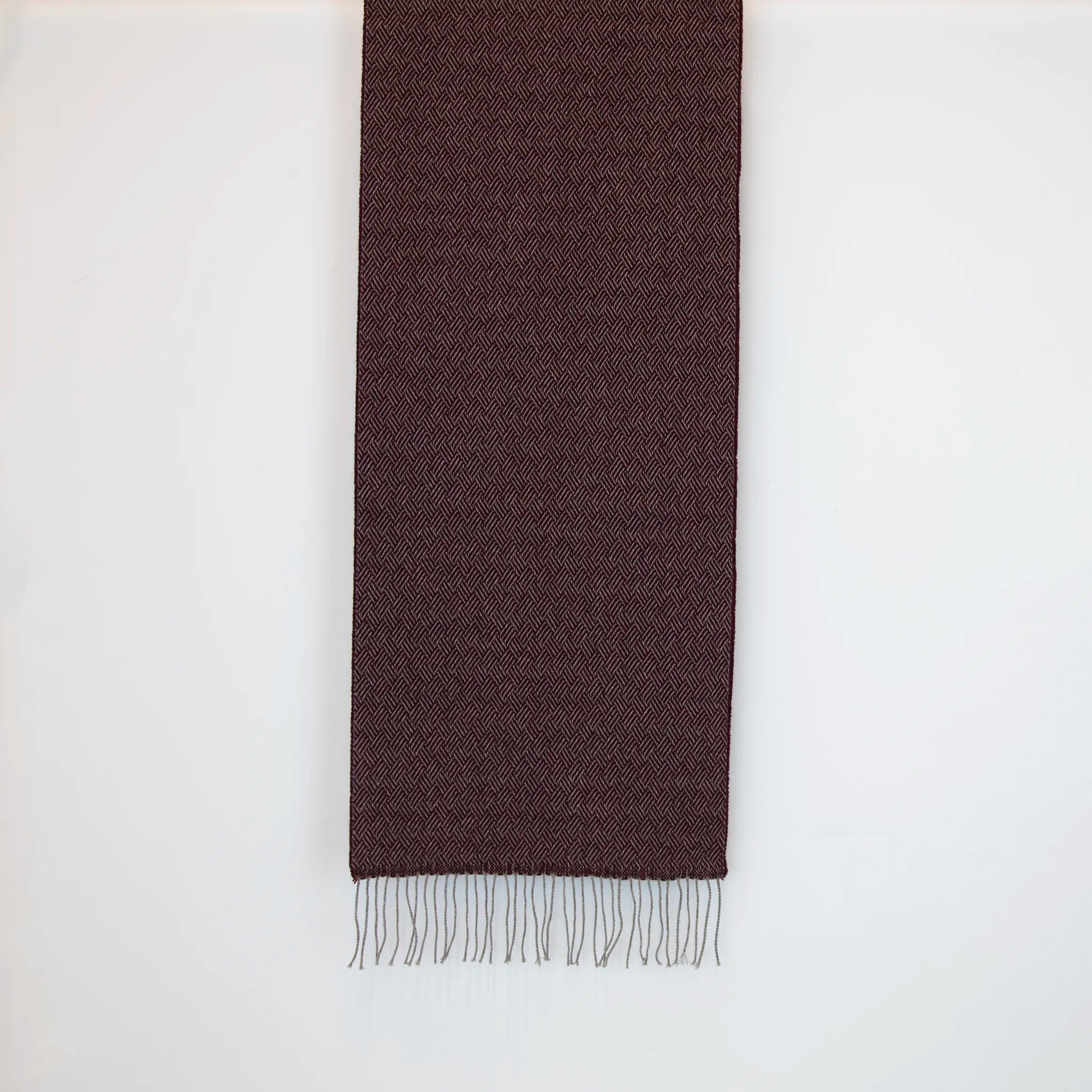 Sciarpa in 100% cashmere bordeaux, Made in Italy, con intramontabile pattern ad intreccio e lavorazione leggera in 3D che accentua la percezione al tatto. Il cashmere di alta qualità offre straordinaria finezza, proprietà termoisolanti e garantisce calore, protezione e leggerezza.