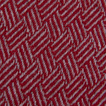 Dettaglio e texture tessuto della Sciarpa in 100% cashmere rossa, Made in Italy, con intramontabile pattern ad intreccio e lavorazione leggera in 3D che accentua la percezione al tatto. Il cashmere di alta qualità offre straordinaria finezza, proprietà termoisolanti e garantisce calore, protezione e leggerezza.