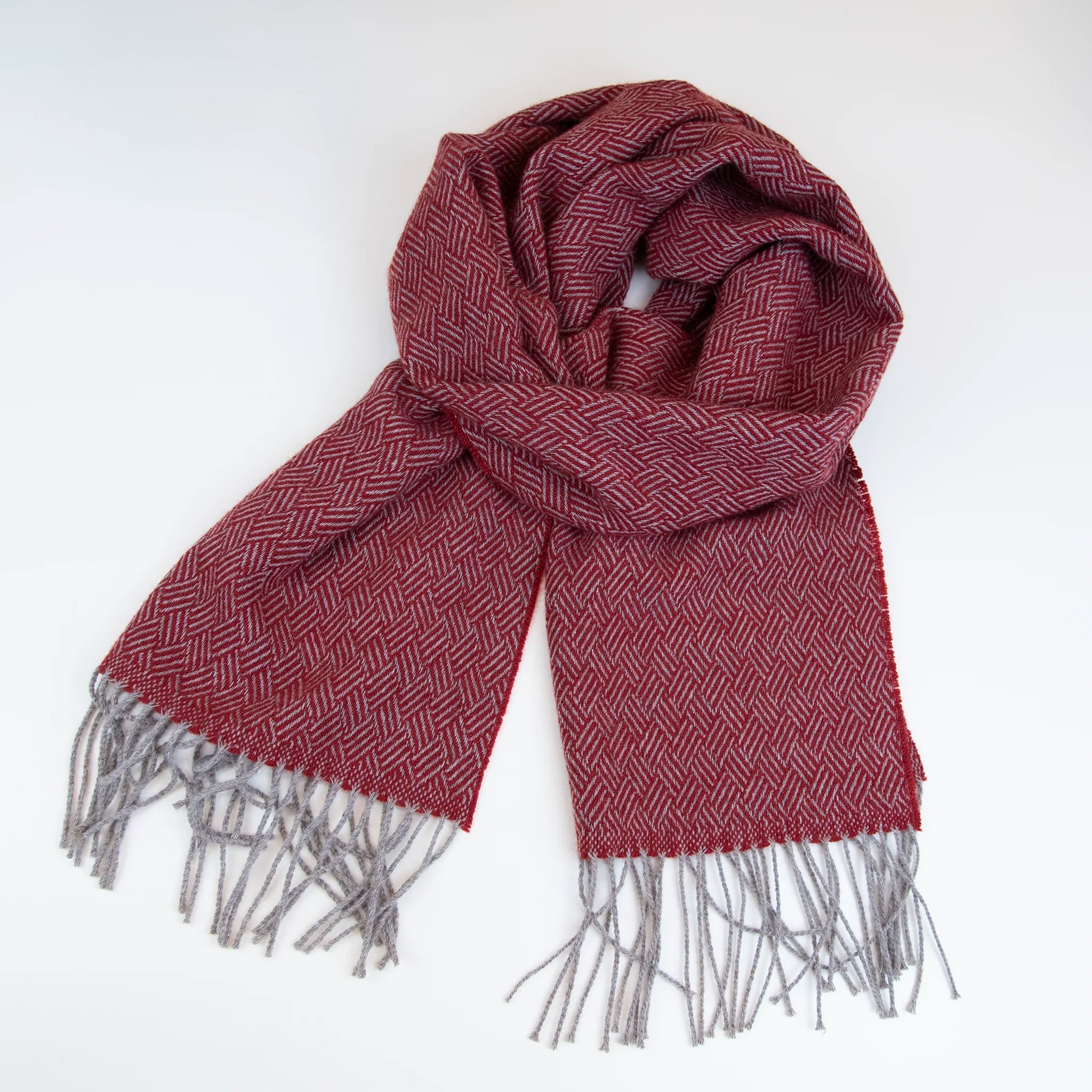 Sciarpa in 100% cashmere rossa, Made in Italy, con intramontabile pattern ad intreccio e lavorazione leggera in 3D che accentua la percezione al tatto. Il cashmere di alta qualità offre straordinaria finezza, proprietà termoisolanti e garantisce calore, protezione e leggerezza.