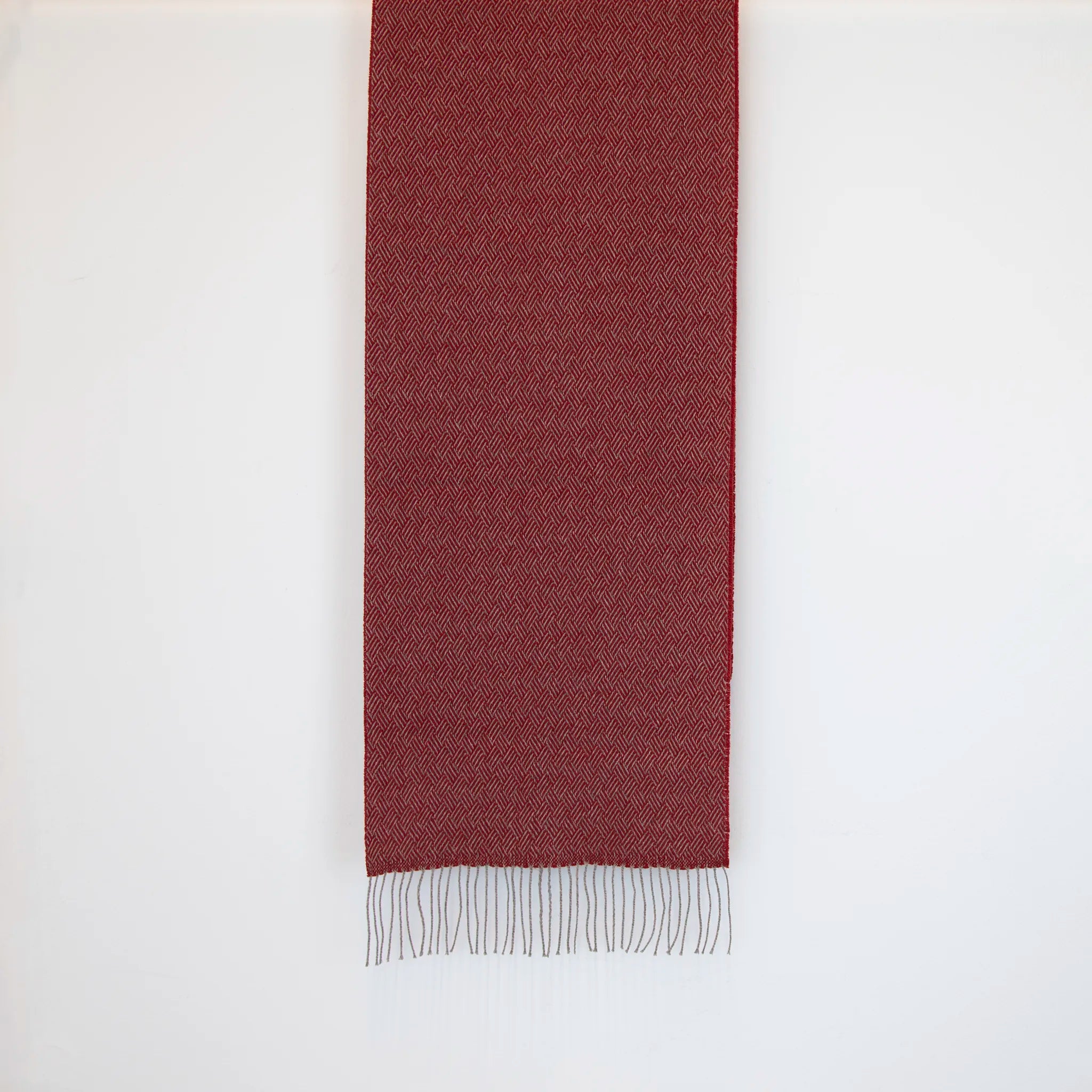 Sciarpa in 100% cashmere rossa, Made in Italy, con intramontabile pattern ad intreccio e lavorazione leggera in 3D che accentua la percezione al tatto. Il cashmere di alta qualità offre straordinaria finezza, proprietà termoisolanti e garantisce calore, protezione e leggerezza.