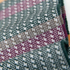 Dettaglio e texture tessuto della sciarpa in 100% cashmere, realizzata in Italia con ricamo 3D su filato naturale, senza pigmenti. Lavorazione artigianale su telai antichi garantisce durata e qualità. Design esclusivo, con colori creati da designer per un capo elegante e versatile.