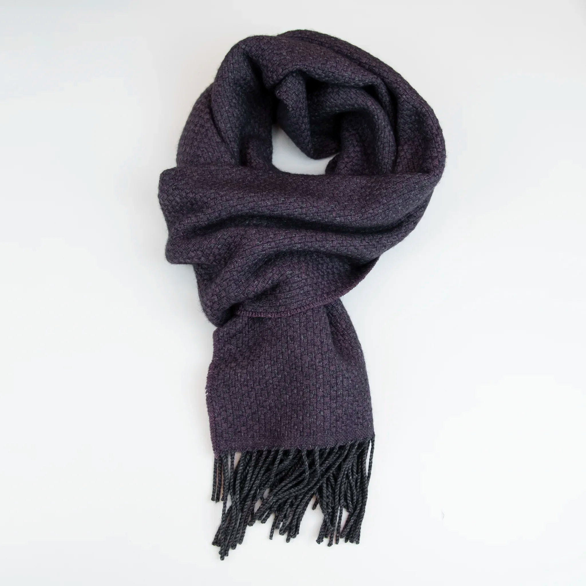 Sciarpa viola in cashmere e seta Made in Italy. La seta dona luminosità alla trama, mentre i telai antichi ne garantiscono durata nel tempo.