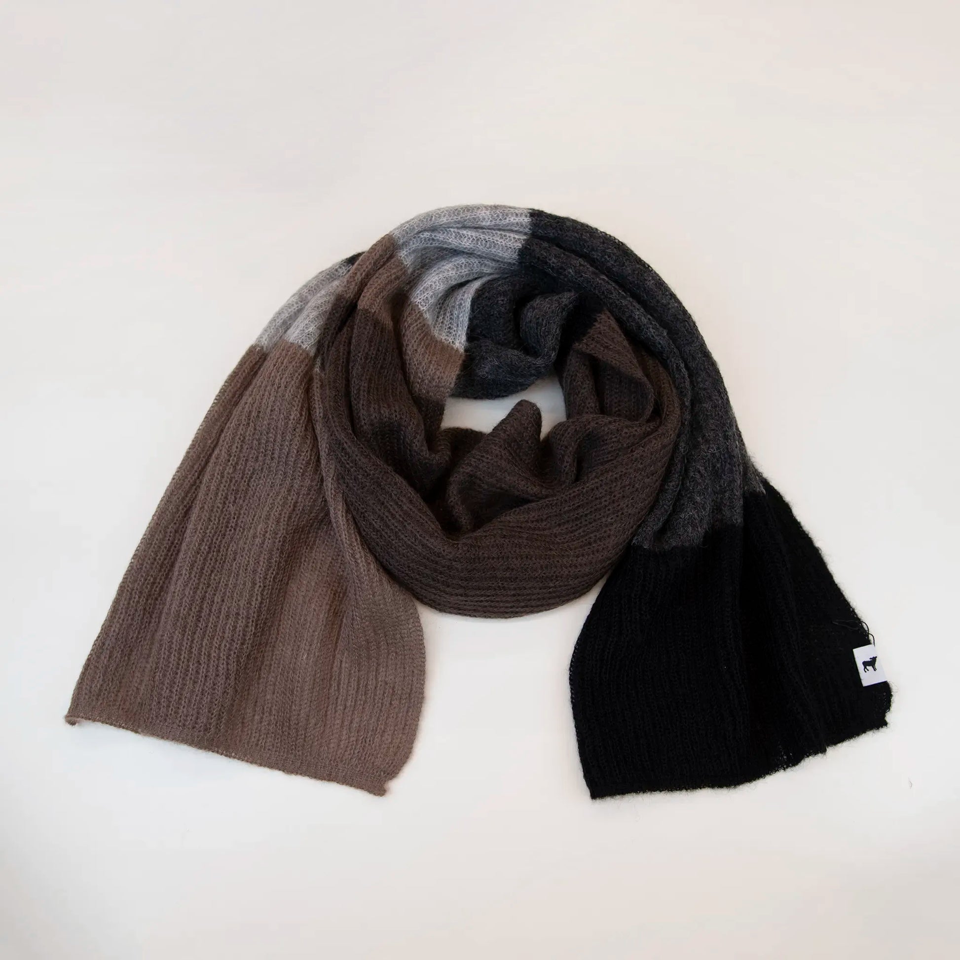 Sciarpa in lana mohair, marrone, Made in Italy, realizzata nel più antico lanificio della Calabria su telai degli anni '30, garantendo qualità e durata nel tempo. I colori ispirati alla vegetazione dell'Appennino Silano evocano freschezza e vitalità di un paesaggio montano incontaminato. Morbida al tatto, offre una sensazione di sofficità che avvolge delicatamente il corpo, per un comfort senza pari.