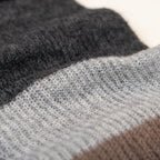 Dettaglio e texture tessuto della sciarpa in lana mohair, marrone, Made in Italy, realizzata nel più antico lanificio della Calabria su telai degli anni '30, garantendo qualità e durata nel tempo. I colori ispirati alla vegetazione dell'Appennino Silano evocano freschezza e vitalità di un paesaggio montano incontaminato. Morbida al tatto, offre una sensazione di sofficità che avvolge delicatamente il corpo, per un comfort senza pari.