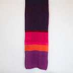 Sciarpa in lana mohair viola, fucsia, arancio, Made in Italy, realizzata nel più antico lanificio della Calabria su telai degli anni '30, garantendo qualità e durata nel tempo. I colori ispirati ai frutti rossi dei boschi evocano calore e naturale bellezza. Morbida al tatto, offre una sensazione di sofficità che avvolge delicatamente il corpo, per un comfort senza pari.