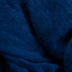 Dettagli e texture tessuto della pashmina blu in 100% cashmere Made in Italy, tessitura a jersey, leggera e vaporosa, perfetta come sciarpa o stola per tutte le stagioni.