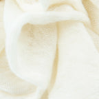 Dettagli e texture tessuto della pashmina panna in 100% cashmere Made in Italy, tessitura a jersey, leggera e vaporosa, perfetta come sciarpa o stola per tutte le stagioni.
