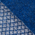 Dettagli e texture della sciarpa scaldacollo Jacquard double-face blu e grigia con asola in 100% Cashmere beige. Morbida, versatile e facile da indossare.