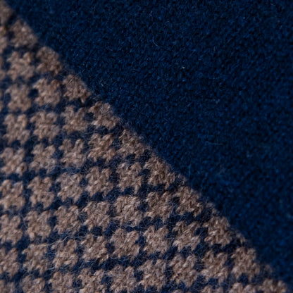 Dettagli e texture della sciarpa scaldacollo Jacquard double-face blu e marrone con asola in 100% Cashmere beige. Morbida, versatile e facile da indossare.