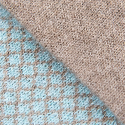 Dettagli e texture tessuto della sciarpa scaldacollo Jacquard double-face celeste e marrone con asola in 100% Cashmere beige. Morbida, versatile e facile da indossare.