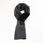 Sciarpa scaldacollo Jacquard double-face nera e grigia con asola in 100% Cashmere beige. Morbida, versatile e facile da indossare.