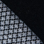Dettagli e texture tessuto della sciarpa scaldacollo Jacquard double-face nera e grigia con asola in 100% Cashmere beige. Morbida, versatile e facile da indossare.