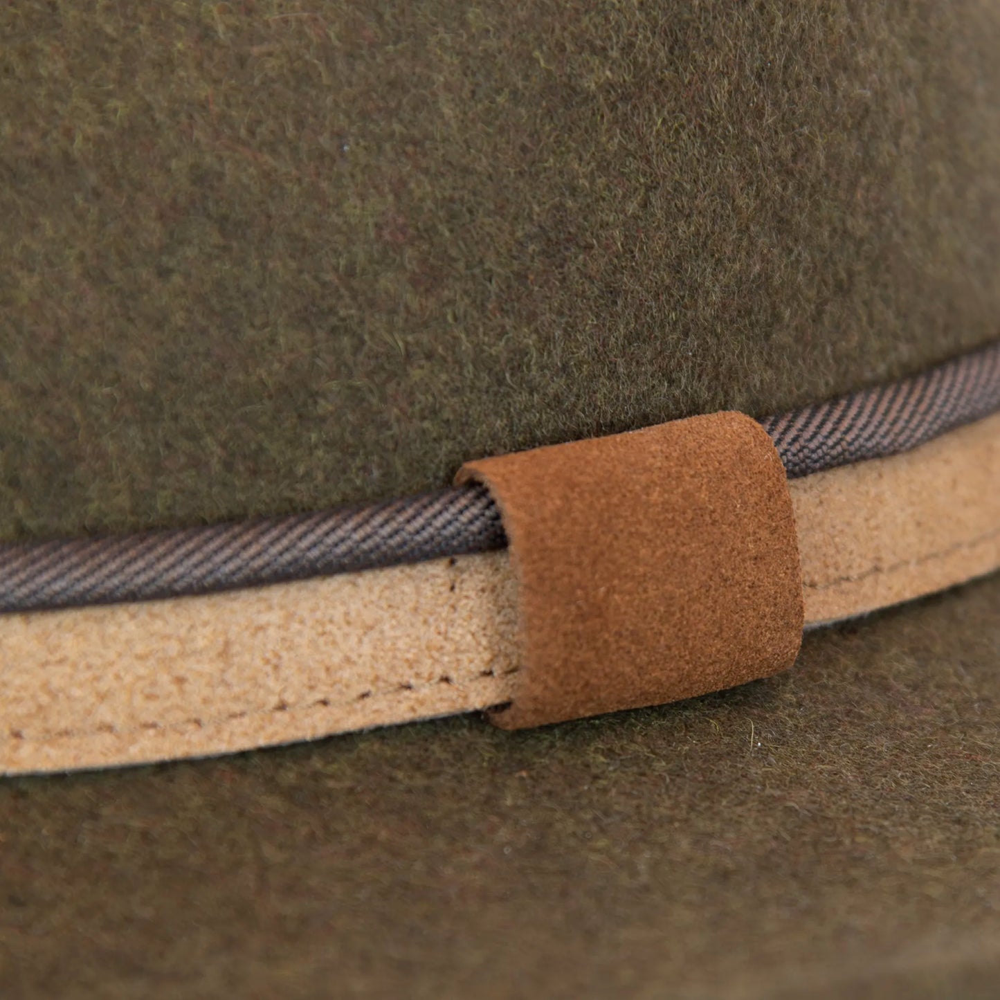 Dettaglio e tessuto del cappello Texano in 100% feltro di lana verde, Made in Italy, con tesa lunga 8 cm e cinta a contrasto da 2,5 cm. Struttura modellabile grazie all’anima in metallo lungo la falda.