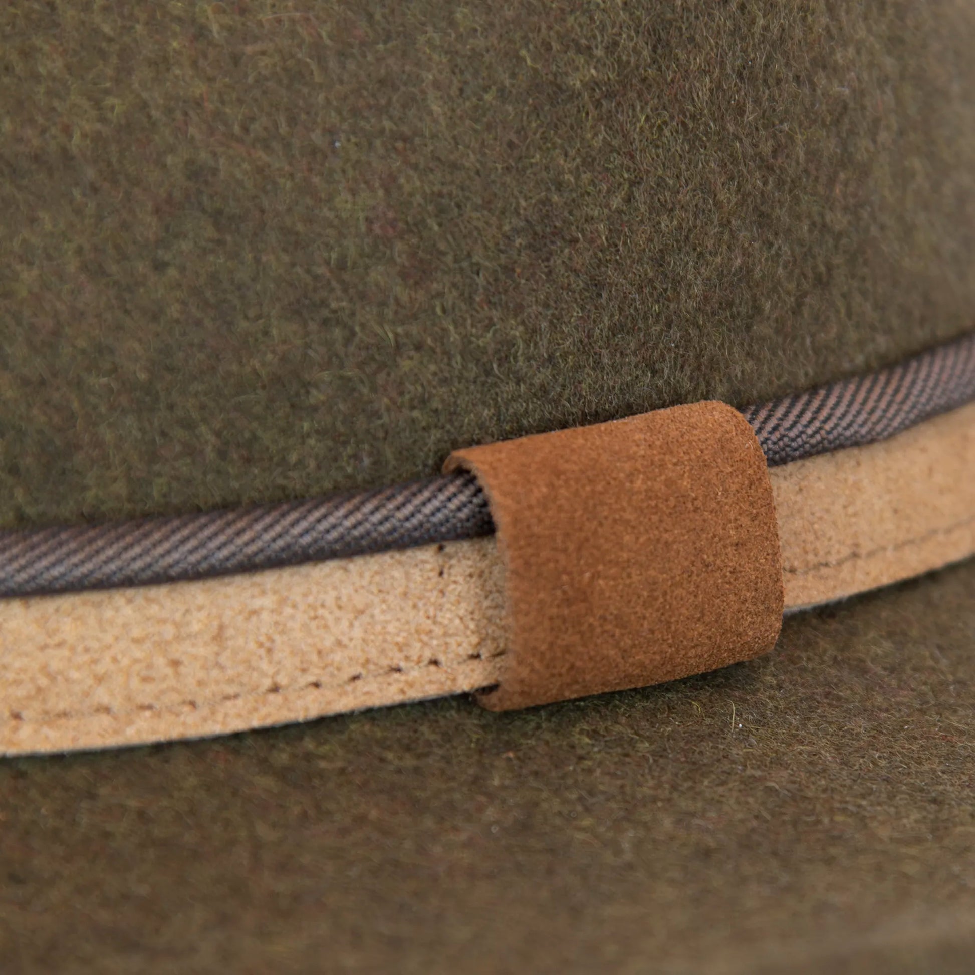Dettaglio e tessuto del cappello Texano in 100% feltro di lana verde, Made in Italy, con tesa lunga 8 cm e cinta a contrasto da 2,5 cm. Struttura modellabile grazie all’anima in metallo lungo la falda.