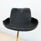 Fronte del cappello Racket in feltro di lana grigio, Made in Italy, realizzato a mano con antiche forme in legno. Cuciture e dettagli di invecchiamento artigianali per un look unico.