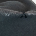 Dettaglio e tessuto del cappello Racket in feltro di lana grigio, Made in Italy, realizzato a mano con antiche forme in legno. Cuciture e dettagli di invecchiamento artigianali per un look unico.