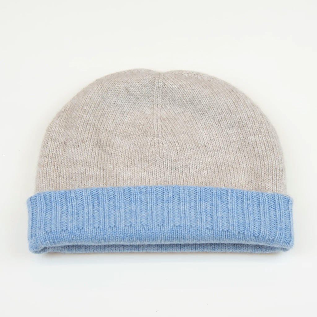 Cuffia doubleface beige e celeste in 100% Cashmere, Made in Italy. Pratica e versatile, può essere indossata con o senza risvolto. Trama rasata e pregiata manifattura per una vestibilità confortevole e di qualità.