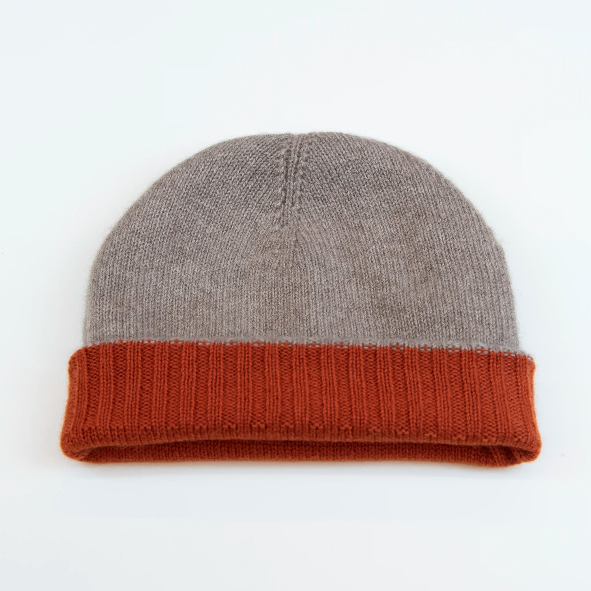 Cuffia doubleface arancio e beige in 100% Cashmere, Made in Italy. Pratica e versatile, può essere indossata con o senza risvolto. Trama rasata e pregiata manifattura per una vestibilità confortevole e di qualità.
