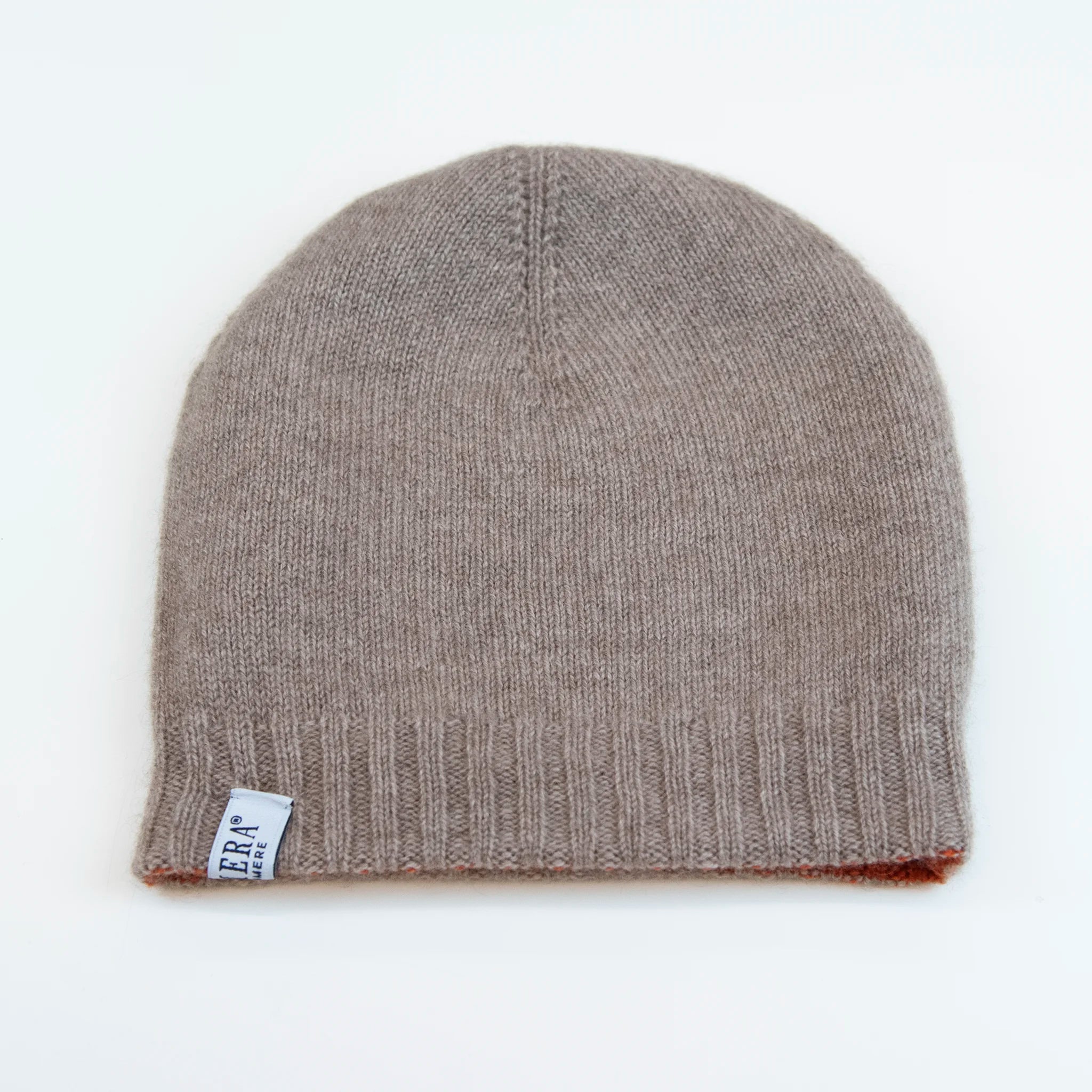 Cuffia doubleface arancio e beige in 100% Cashmere, Made in Italy. Pratica e versatile, può essere indossata con o senza risvolto. Trama rasata e pregiata manifattura per una vestibilità confortevole e di qualità.