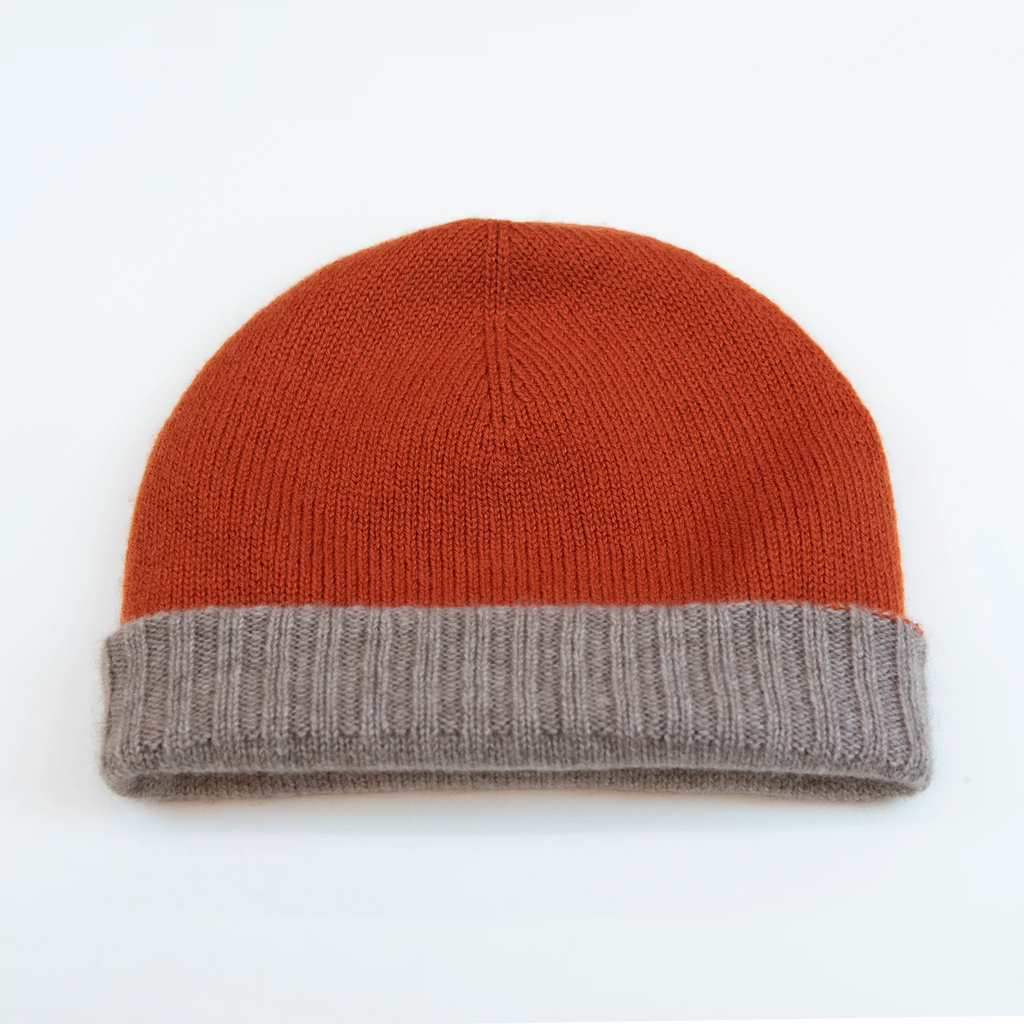 Cuffia doubleface arancio e beige in 100% Cashmere, Made in Italy. Pratica e versatile, può essere indossata con o senza risvolto. Trama rasata e pregiata manifattura per una vestibilità confortevole e di qualità.