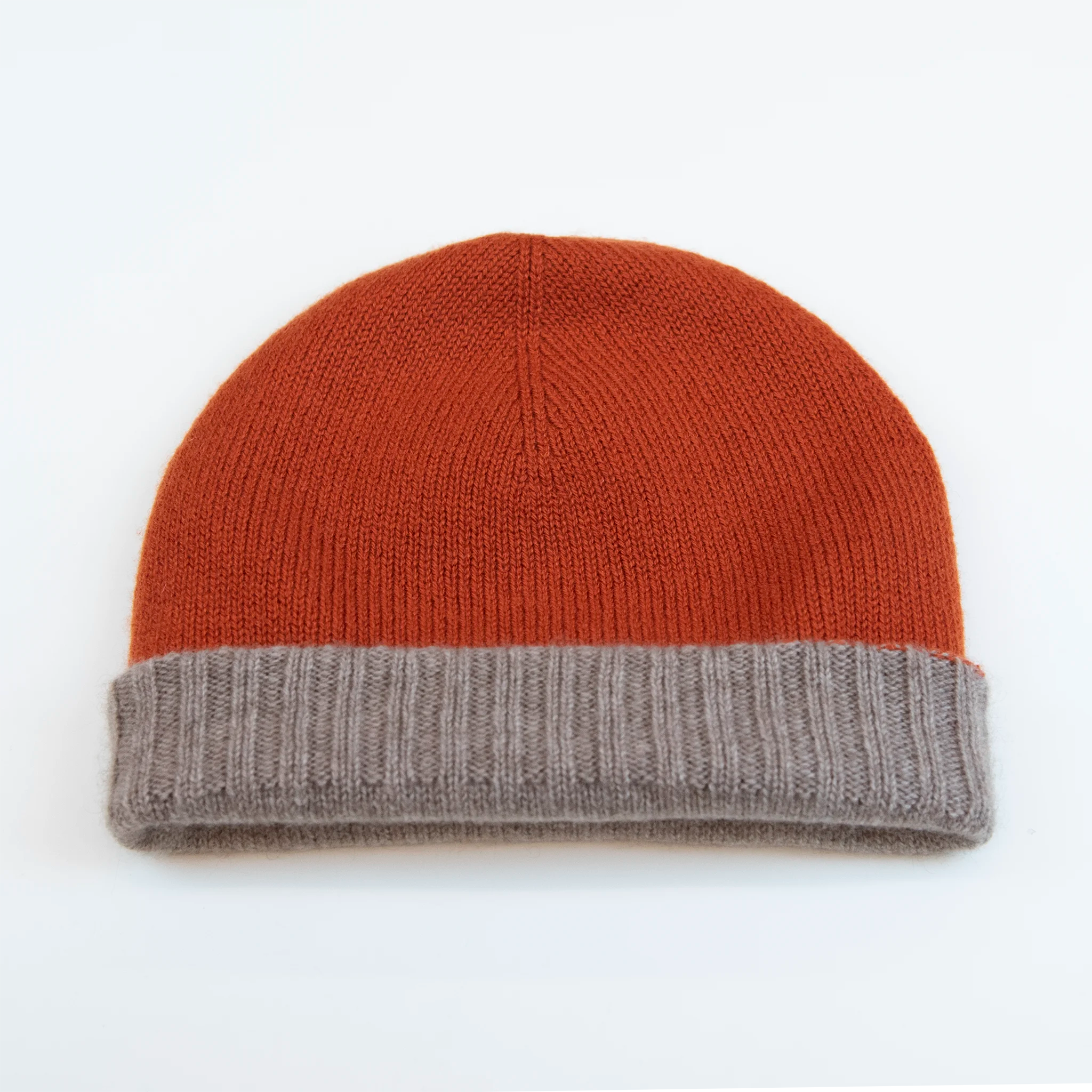 Cuffia doubleface arancio e beige in 100% Cashmere, Made in Italy. Pratica e versatile, può essere indossata con o senza risvolto. Trama rasata e pregiata manifattura per una vestibilità confortevole e di qualità.