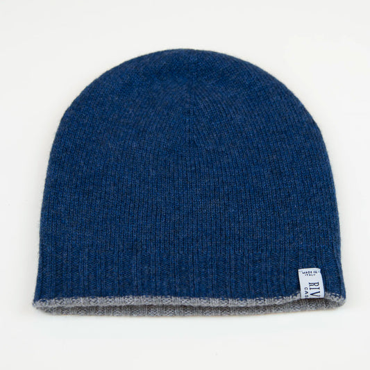 Cuffia doubleface grigio e blu in 100% Cashmere, Made in Italy. Pratica e versatile, può essere indossata con o senza risvolto. Trama rasata e pregiata manifattura per una vestibilità confortevole e di qualità.