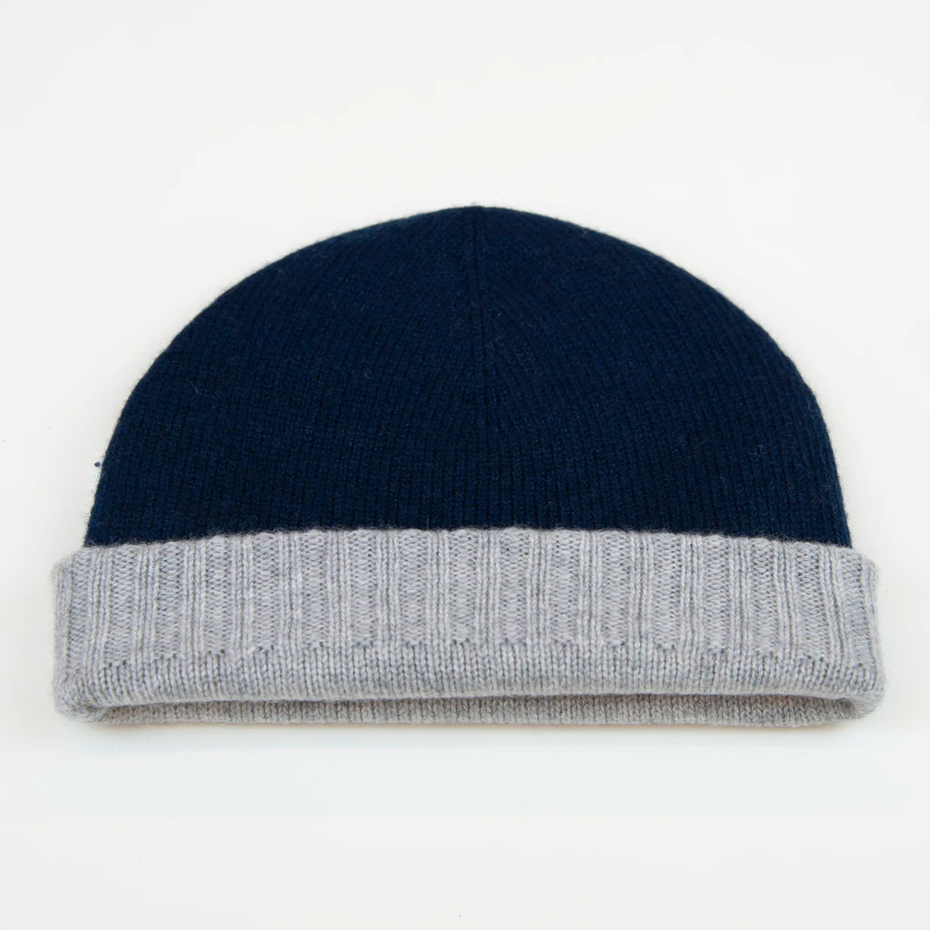 Cuffia doubleface grigio e blu in 100% Cashmere, Made in Italy. Pratica e versatile, può essere indossata con o senza risvolto. Trama rasata e pregiata manifattura per una vestibilità confortevole e di qualità.