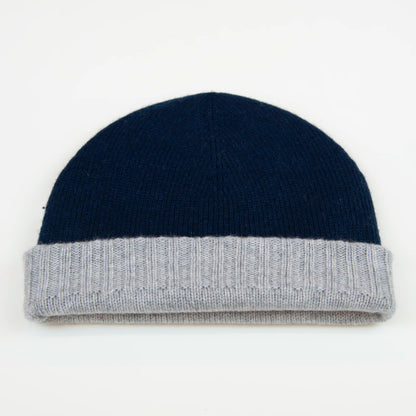 Cuffia doubleface grigio e blu in 100% Cashmere, Made in Italy. Pratica e versatile, può essere indossata con o senza risvolto. Trama rasata e pregiata manifattura per una vestibilità confortevole e di qualità.